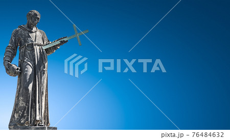 Banner with very old roof statute of high ranked priest with a cross and human skull in historical downtown of Dresden, Germany, copy space, details, closeup 76484632