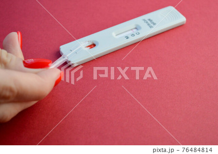 test for coronavirus on a red background. girl with a bright red manicure makes a blood test. determination of IgG and IgM antibodies 76484814