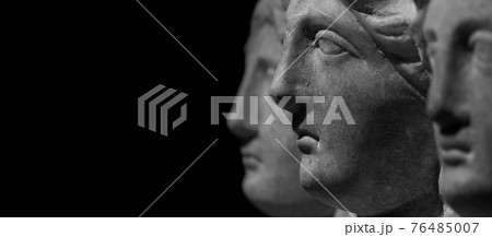 Marble ancient different heads as humankind in a isolated black background, streamer, banner with paste space 76485007