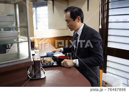 定食屋でランチをとるサラリーマン 定食屋でランチをとるサラリーマン 76487896