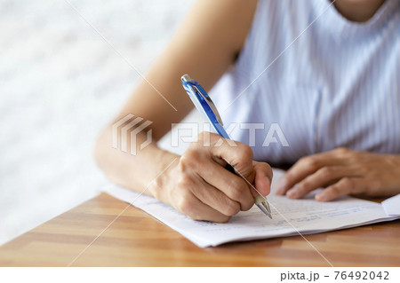 Close up hand of business women use pen writing document paper. Female hand close up writing with a blue pen on a white sheet. Woman writes information on a piece of paper. Close up hand of business women use pen writing document paper. Female hand close up writing with a blue pen on a white sheet. Woman writes information on a piece of paper. 76492042