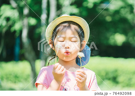 たんぽぽの綿毛を吹く女の子 たんぽぽの綿毛を吹く女の子 76492098