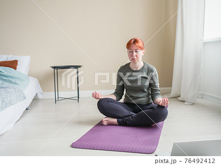 Front view to young woman meditate in bedroom 76492412