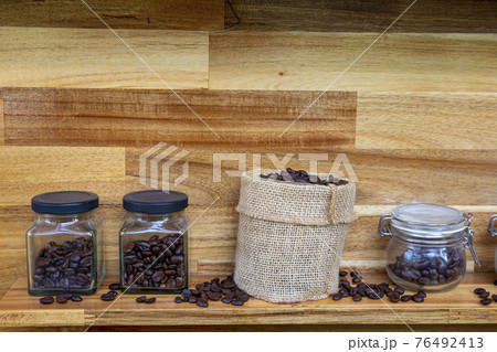 Coffee beans in a crystal jar on a brown wooden backgroundand 76492413