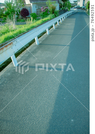 ノスタルジックな街中の風景　用水路とガードレール　 76492591