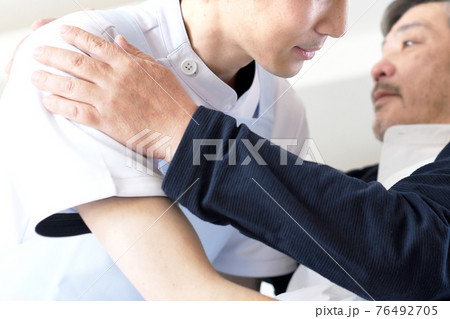 ベッドでお年寄りの男性を起こす介護士の男性 ベッドでお年寄りの男性を起こす介護士の男性 76492705