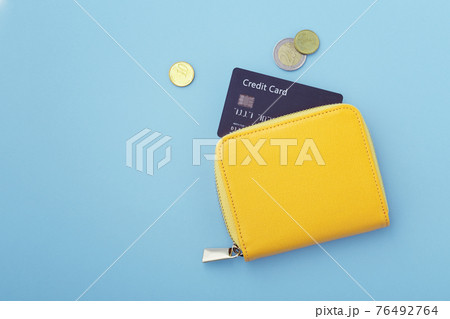 Credit card in wallet with coins on blue background 76492764