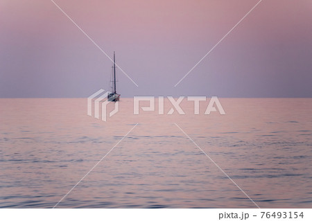 Sailing yacht in the blue sea during beautiful pink sunset. Sailing yacht in the blue sea during beautiful pink sunset. 76493154