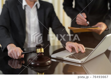 Business people and lawyers discussing contract papers sitting in the table at office in the morning. concepts of law, advice, legal services. Business people and lawyers discussing contract papers sitting in the table at office in the morning. concepts of law, advice, legal services. 76493667