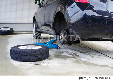 ガレージで車のタイヤ交換 76496383