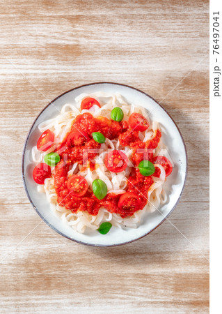 Konjac pasta with tomato sauce, shot from the top on a wooden background Konjac pasta with tomato sauce, shot from the top on a wooden background 76497041