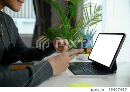 Cropped shot of man freelancer working online with tablet computer and using mobile phone. 76497447