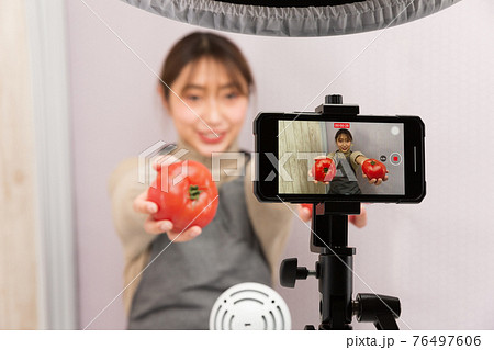 スマートフォンで動画を撮影する女性 スマートフォンで動画を撮影する女性 76497606