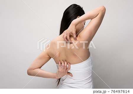 背中を掻く女性 背中を掻く女性 76497614