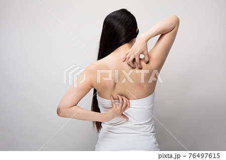 背中を掻く女性 76497615