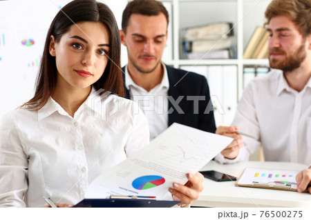 Beautiful smiling cheerful girl at workplace look in camera Beautiful smiling cheerful girl at workplace look in camera 76500275
