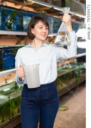 Woman holding plastic bag with fish Woman holding plastic bag with fish 76500471