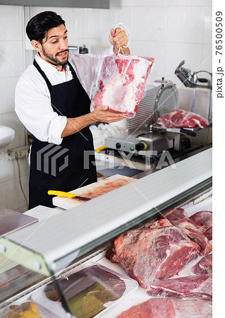 Man butcher is demonstraiting meat in the market. Man butcher is demonstraiting meat in the market. 76500509