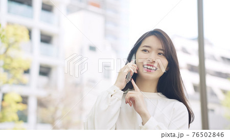 街を歩きながらスマホで通話する女性 街を歩きながらスマホで通話する女性 76502846