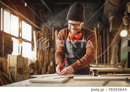 Joiner working with wooden detail in workshop 76503644