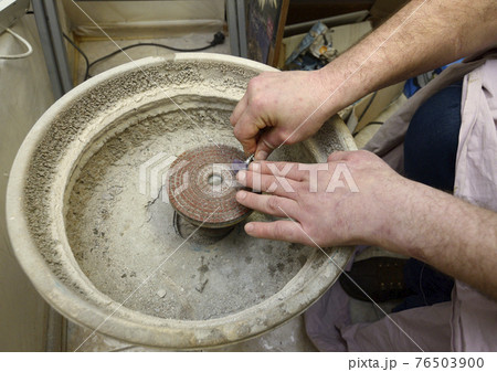 At the workshop: Technician grinds mineral using grinding wheel 76503900