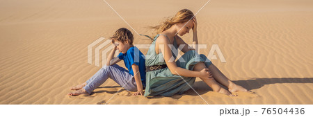 BANNER, LONG FORMAT Relationship problems between mother and son. Family conflict. Mom and son have a heated relationship, sit in the hot desert with their backs to each other and do not want to talk BANNER, LONG FORMAT Relationship problems between mother and son. Family conflict. Mom and son have a heated relationship, sit in the hot desert with their backs to each other and do not want to talk 76504436
