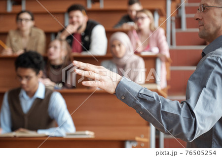 Hand of professor in casualwear standing in front of audience and explaining subject of lecture Hand of professor in casualwear standing in front of audience and explaining subject of lecture 76505254