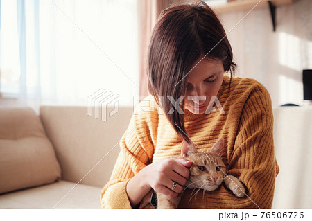 Young woman resting with pet in sofa at home. 76506726