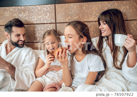Girls eating croissants and looking excited Girls eating croissants and looking excited 76507922