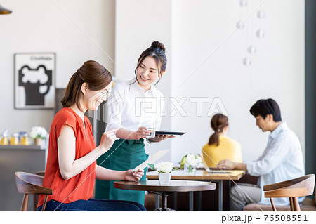 カフェで注文する若い女性と接客するスタッフ カフェで注文する若い女性と接客するスタッフ 76508551