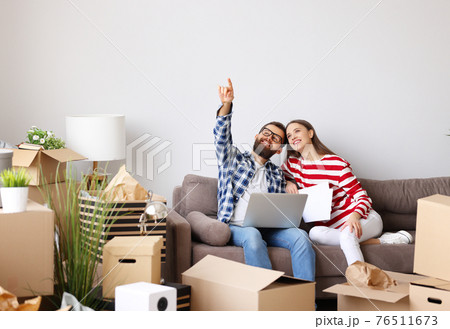 Content couple with laptop planning design of new apartment 76511673