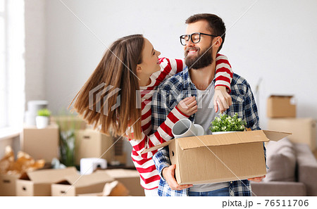 Cheerful couple with carton boxes together in new flat Cheerful couple with carton boxes together in new flat 76511706