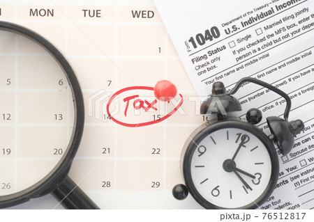 tax day concept with red circle on calendar date and tax return on table  76512817