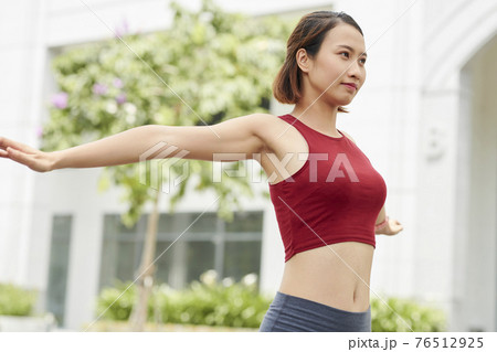 Sportswoman warming up 76512925