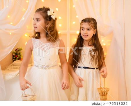 portrait of a child girls in home interior decorated with holiday lights and gifts portrait of a child girls in home interior decorated with holiday lights and gifts 76513022