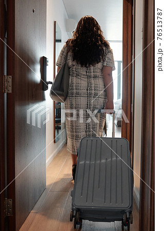 Woman entering hotel room Woman entering hotel room 76513787
