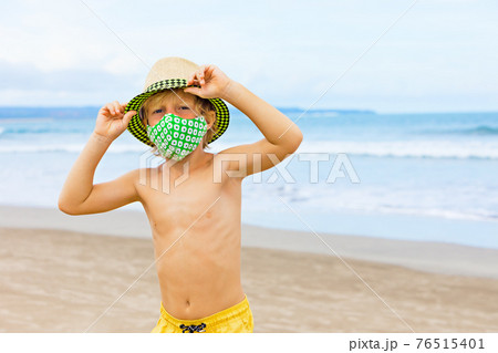 Child in face masks have fun on sea beach 76515401
