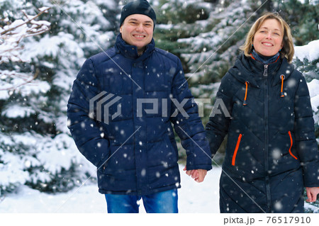 couple walking in a winter forest, two adult people, man and woman, beautiful nature with bright snowy fir trees couple walking in a winter forest, two adult people, man and woman, beautiful nature with bright snowy fir trees 76517910
