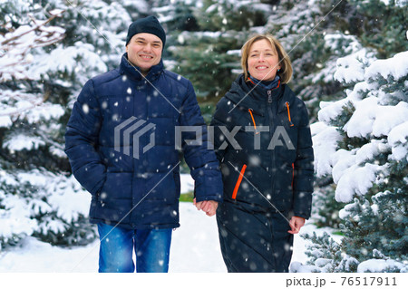 couple walking in a winter forest, two adult people, man and woman, beautiful nature with bright snowy fir trees couple walking in a winter forest, two adult people, man and woman, beautiful nature with bright snowy fir trees 76517911