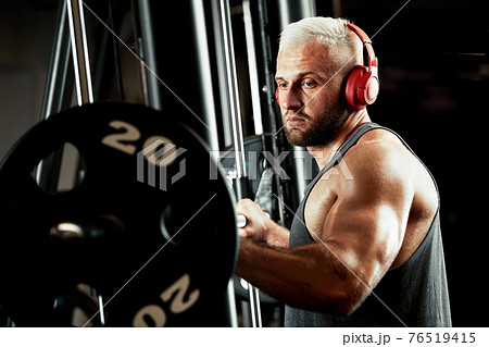 Closeup portrait of a muscular man workout with barbell at gym. Brutal bodybuilder athletic man with six pack, perfect abs, shoulders, biceps, triceps and chest 76519415