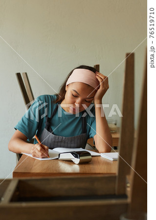 Young Woman doing Taxes 76519710