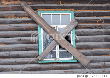 a boarded-up window of a wooden house with broken glass a boarded-up window of a wooden house with broken glass 76520314