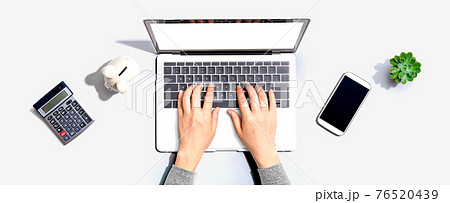 Woman using a laptop computer with a piggy bank 76520439