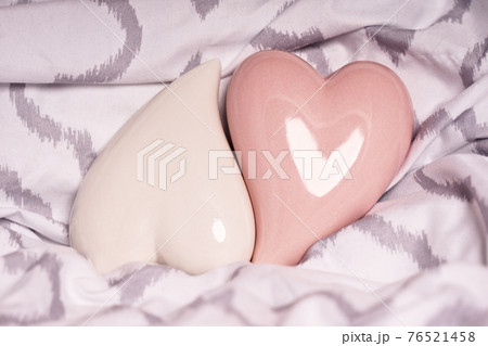Two red hearts on a modern bedsheet Two red hearts on a modern bedsheet 76521458