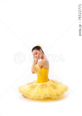 Young modern ballerina with yellow tutu doing the pose on white background. 76522771