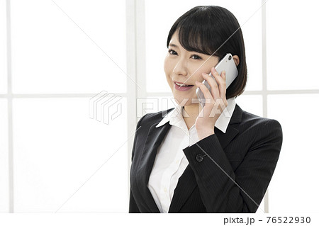 スーツ姿で電話をする若い女性 スーツ姿で電話をする若い女性 76522930