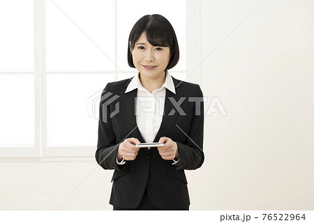 スーツ姿で名刺を差し出す若い女性(正面) スーツ姿で名刺を差し出す若い女性(正面) 76522964