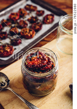 Preserving of Sun Dried Tomatoes with Thyme in a Jar 76522980