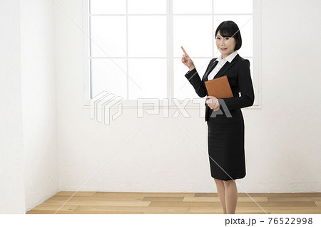 スーツ姿でシステム手帳を持ってポーズをとる女性 スーツ姿でシステム手帳を持ってポーズをとる女性 76522998