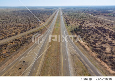 Aerial view of long road through desert landscape towards near San Jon New Mexico USA Aerial view of long road through desert landscape towards near San Jon New Mexico USA 76524646